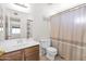 Cozy bathroom with sink and counter, a toilet, and a shower behind a curtain at 659 S Dodge St, Gilbert, AZ 85233