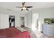 Bright bedroom featuring a ceiling fan, wood-look flooring, and access to the connected bathroom at 659 S Dodge St, Gilbert, AZ 85233