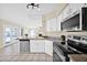 White kitchen features stainless steel appliances, a breakfast bar, and an open view to the living area at 659 S Dodge St, Gilbert, AZ 85233
