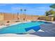Inviting pool area featuring rock waterfall features, lush landscaping, and a spacious patio, creating a peaceful oasis at 659 S Dodge St, Gilbert, AZ 85233