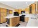Kitchen with island, wood cabinets, and modern appliances at 8903 N 57Th Dr, Glendale, AZ 85302