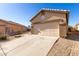 View of the home's garage and driveway, with desert landscaping at 1102 N 5Th St, Buckeye, AZ 85326