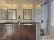 Bathroom with double sinks, dark wood cabinets, and a large walk-in shower at 14335 W Country Gables Dr, Surprise, AZ 85379