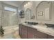 Bathroom with double sinks, dark wood cabinets, and a shower/tub combo at 14335 W Country Gables Dr, Surprise, AZ 85379