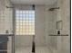 Walk-in shower with glass enclosure, tile flooring, and a built-in niche at 14335 W Country Gables Dr, Surprise, AZ 85379