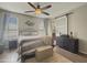 Main bedroom with barn door to bathroom and ceiling fan at 14335 W Country Gables Dr, Surprise, AZ 85379