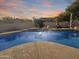 Stunning pool at sunset with fire pit and water feature at 14335 W Country Gables Dr, Surprise, AZ 85379
