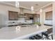 An open-concept kitchen with an island and stainless steel appliances, seamlessly flowing into dining and living areas at 24301 N 194Th Ave, Surprise, AZ 85387
