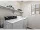 Bright laundry room with washer, dryer, and shelving at 2838 E Shady Spring Trl, Phoenix, AZ 85024