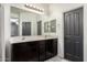 Bathroom with double vanity, dark wood cabinets, and a large mirror at 31310 N 26Th Dr, Phoenix, AZ 85085