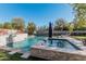 Stunning pool and spa with a stonework feature and basketball hoop at 4605 E Orange Dr, Phoenix, AZ 85018