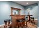 Home bar with wood cabinetry and black leather barstools at 5781 W Ross Dr, Chandler, AZ 85226