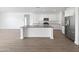 Modern kitchen with island, white cabinets, and stainless steel appliances at 703 W Magena Dr, San Tan Valley, AZ 85140