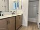Modern bathroom with double sinks, quartz countertops, and a combined shower and tub at 7638 W Rowel Rd, Peoria, AZ 85383