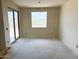 This unfinished bedroom with a sliding glass door offers potential for customization and showcases natural light at 7638 W Rowel Rd, Peoria, AZ 85383