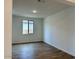 Sunlit bedroom with wood-look tile flooring, white walls, and a large window with a view at 7638 W Rowel Rd, Peoria, AZ 85383