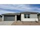 Charming single-story home featuring a gray facade, a gray garage door, and simple landscaping at 7638 W Rowel Rd, Peoria, AZ 85383