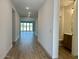 Bright hallway with wood-look tile flooring, recessed lighting, and a view of the living area at 7638 W Rowel Rd, Peoria, AZ 85383