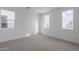 Bright bedroom with neutral carpeting, two large windows, and a spacious layout at 10236 E Ursula Ave, Mesa, AZ 85212