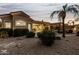 Landscaped backyard at dusk with a view of the house and palm trees at 10310 E Posada Ave, Mesa, AZ 85212