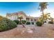 Landscaped backyard with gravel, bushes, and a partial view of the house at 10310 E Posada Ave, Mesa, AZ 85212