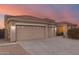 Tan house with a three car garage and a landscaped yard at 10310 E Posada Ave, Mesa, AZ 85212