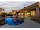 Stunning pool area at dusk with a covered patio and lighting at 10310 E Posada Ave, Mesa, AZ 85212