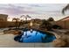 Backyard oasis with a kidney-shaped pool, patio, and palm trees at 10310 E Posada Ave, Mesa, AZ 85212