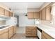 View of kitchen with wood cabinets, tiled backsplash and a breakfast bar at 10343 W Prairie Hills Cir, Sun City, AZ 85351