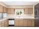 Bright kitchen features wood cabinets, updated appliances, and a window overlooking the backyard at 10343 W Prairie Hills Cir, Sun City, AZ 85351