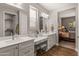 Elegant bathroom with double vanity, large mirrors, and a view of the bedroom at 16925 W Virginia Ave, Goodyear, AZ 85395