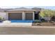 Two-car garage and front entrance of home with desert landscaping at 16925 W Virginia Ave, Goodyear, AZ 85395