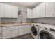 Bright laundry room with washer, dryer, cabinets, and a sink at 16925 W Virginia Ave, Goodyear, AZ 85395