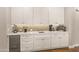 Modern wet bar with white cabinets, quartz countertops, and wine rack at 16925 W Virginia Ave, Goodyear, AZ 85395