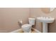 Clean bathroom with pedestal sink, toilet, and neutral color scheme at 30213 N 124Th Ln, Peoria, AZ 85383