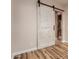 Bedroom with wood-look floors, barn door, and access to bathroom at 30213 N 124Th Ln, Peoria, AZ 85383