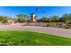 Attractive community entrance with landscaping and flags at 30213 N 124Th Ln, Peoria, AZ 85383