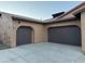 Two-car garage with dark brown doors and smooth concrete driveway at 30213 N 124Th Ln, Peoria, AZ 85383