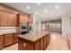 Open kitchen with large island, stainless steel appliances, and wood cabinets at 30213 N 124Th Ln, Peoria, AZ 85383