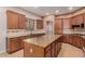 Spacious kitchen with an island, stainless steel appliances, and wood cabinets at 30213 N 124Th Ln, Peoria, AZ 85383