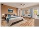 Comfortable main bedroom suite with ceiling fan, natural light, ensuite bathroom, and stylish furniture at 30213 N 124Th Ln, Peoria, AZ 85383