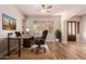 Bright home office featuring wood floors, fan, modern desk, comfortable chair and plenty of natural light at 30213 N 124Th Ln, Peoria, AZ 85383