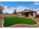 Spacious backyard with artificial turf and a covered patio at 3041 E Wahalla Ln, Phoenix, AZ 85050