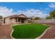 Landscaped backyard with artificial turf and a covered patio at 3041 E Wahalla Ln, Phoenix, AZ 85050