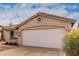 Tan house with a two-car garage and yellow flowers at 3041 E Wahalla Ln, Phoenix, AZ 85050