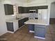 Well-lit kitchen with modern countertops and gray cabinets, complete with an island and stainless steel appliances at 3041 E Wahalla Ln, Phoenix, AZ 85050