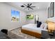 Bright bedroom with a mustard yellow bed, large window, and TV at 3322 N Valencia Ln, Phoenix, AZ 85018