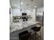 Updated kitchen boasts stainless steel appliances, modern lighting, and ample counter space with bar stool seating at 3614 N 48Th Dr, Phoenix, AZ 85031