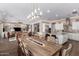 Open concept kitchen and dining area with large island, stainless steel appliances, and rustic wooden dining table at 36709 N Stoneware Dr, Queen Creek, AZ 85140