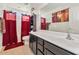 Clean bathroom with a double vanity, bathtub, and burgundy accents at 4122 S 185Th Ln, Goodyear, AZ 85338